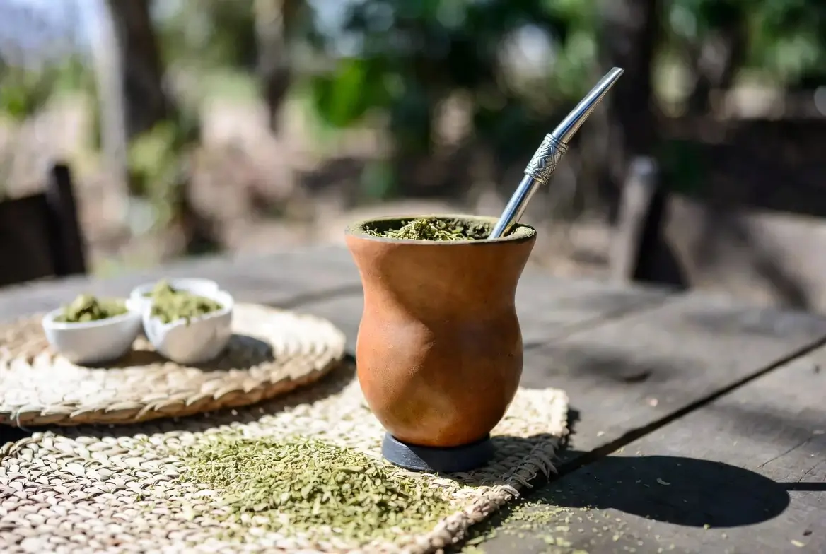 Tradycyjne matero z suszem yerba mate na drewnianym stole
